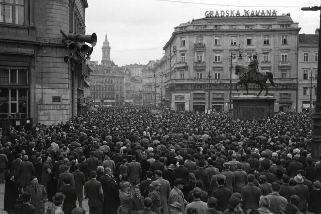 A large crowd gathered on Ban Jelačić Square under loudspeakers, the equestrian monument at right